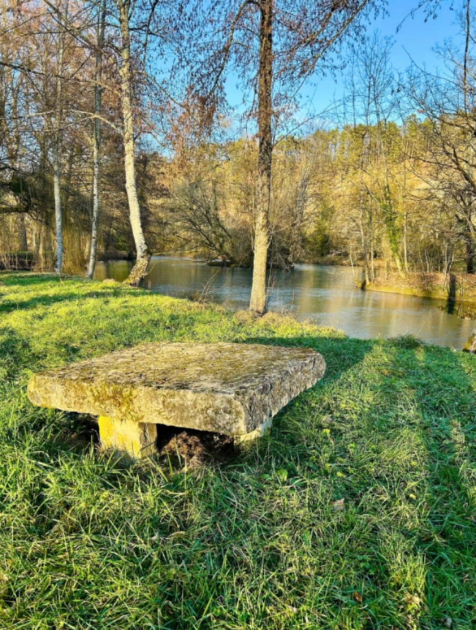 un banc en pierre sur le bord d'un des étangs, inviitation à la détente et la rêverie